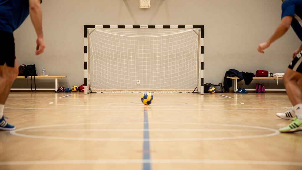 Équipe de handball en pleine phase d'attaque en salle